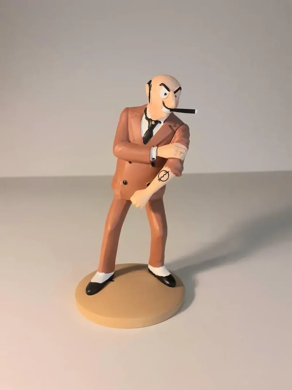 Figurine de Rastapopoulos montrant son tatouage, fabriquée en résine. Modèle réduit pour collectionneur. Taille 12 cm. Ne convient pas aux enfants de moins de 14 ans.