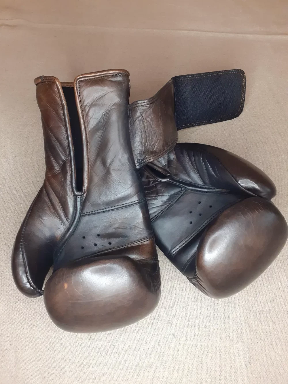 Gants de boxe marron vintage, cuire pleine fleur patiné à la main. Garnissage en mousse haute densité, fermeture : velcro au poignet.