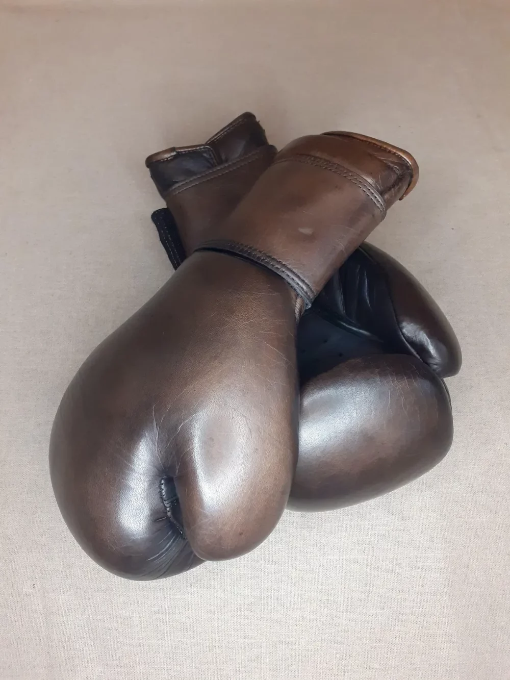 Gants de boxe marron vintage, cuire pleine fleur patiné à la main. Garnissage en mousse haute densité, fermeture : velcro au poignet.