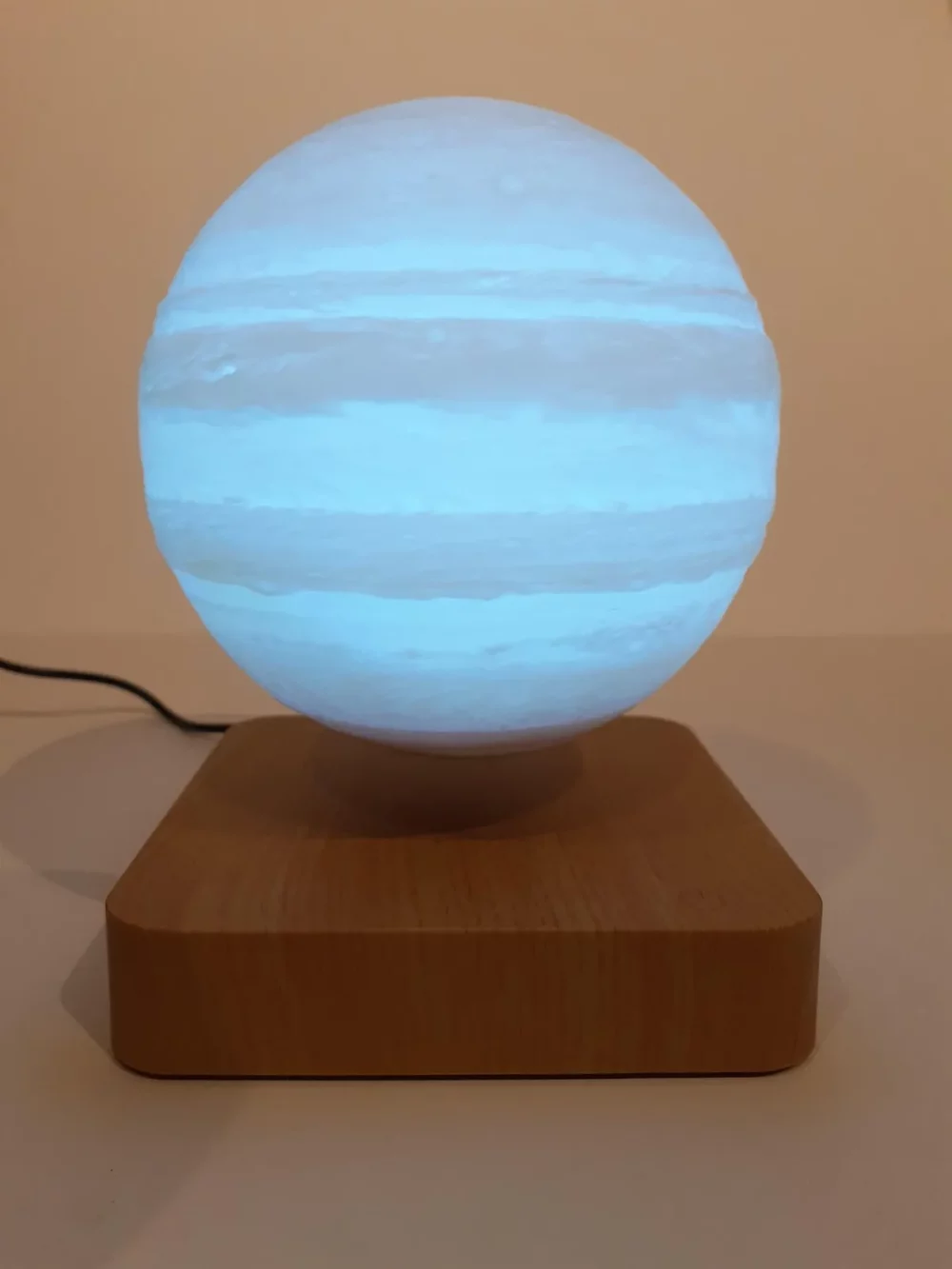 Ce globe représentant Jupiter en lévitation au dessus de son socle en bois émerveillera à coup sûr ses observateurs. Il diffuse par rétro-éclairage interne une lumière radiale tamisée avec 3 coloris au choix