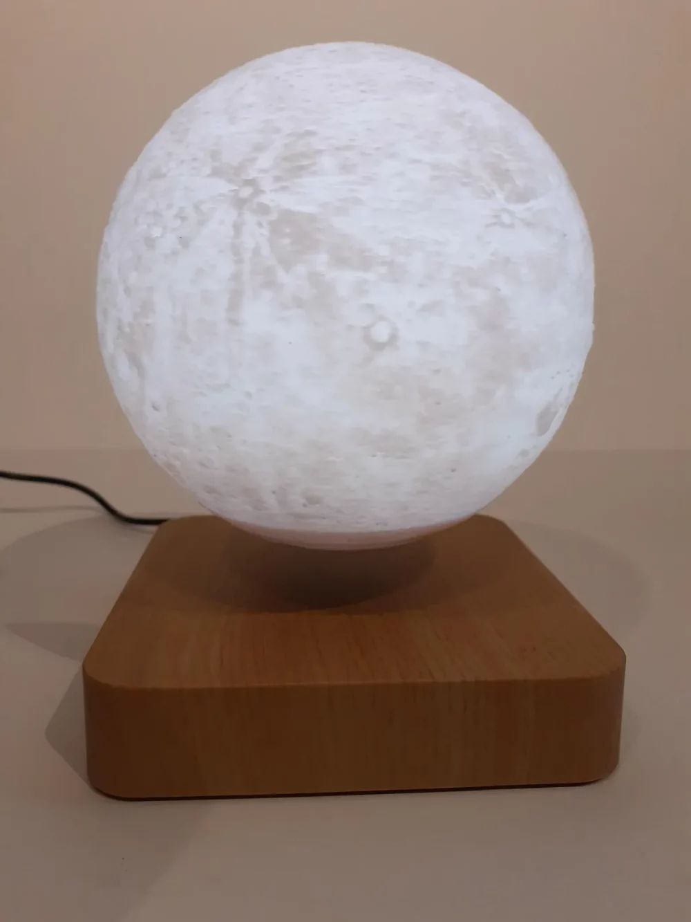 Ce globe représentant la lune en lévitation au dessus de son socle en bois émerveillera à coup sûr ses observateurs. Il diffuse par rétro-éclairage interne une lumière radiale tamisée avec 3 coloris au choix.