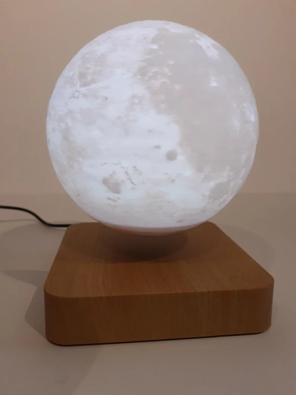 Ce globe représentant la lune en lévitation au dessus de son socle en bois émerveillera à coup sûr ses observateurs. Il diffuse par rétro-éclairage interne une lumière radiale tamisée avec 3 coloris au choix.