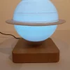 Ce globe représentant la planète Saturne en lévitation au dessus de son socle en bois émerveillera à coup sûr ses observateurs. Il diffuse par rétro-éclairage interne une lumière radiale tamisée avec 3 coloris au choix.