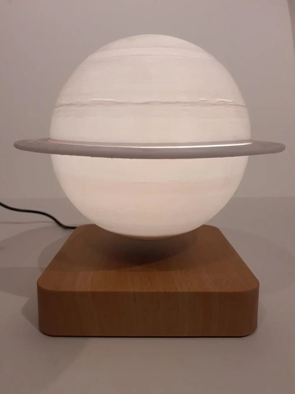 Ce globe représentant la planète Saturne en lévitation au dessus de son socle en bois émerveillera à coup sûr ses observateurs. Il diffuse par rétro-éclairage interne une lumière radiale tamisée avec 3 coloris au choix.