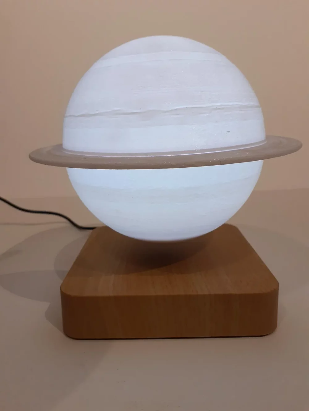 Ce globe représentant la planète Saturne en lévitation au dessus de son socle en bois émerveillera à coup sûr ses observateurs. Il diffuse par rétro-éclairage interne une lumière radiale tamisée avec 3 coloris au choix.