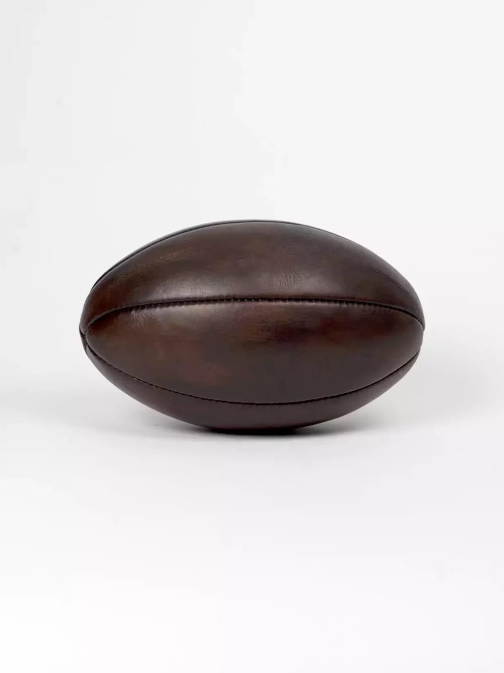 Ballon de rugby marron vintage, cuir pleine fleur composé de 6 panneaux cousus main. Chambre à air en latex. Élégant et stylé, cet exemplaire vintage fabriquée à l'ancienne servira à donner un aspect authentique à votre décoration.