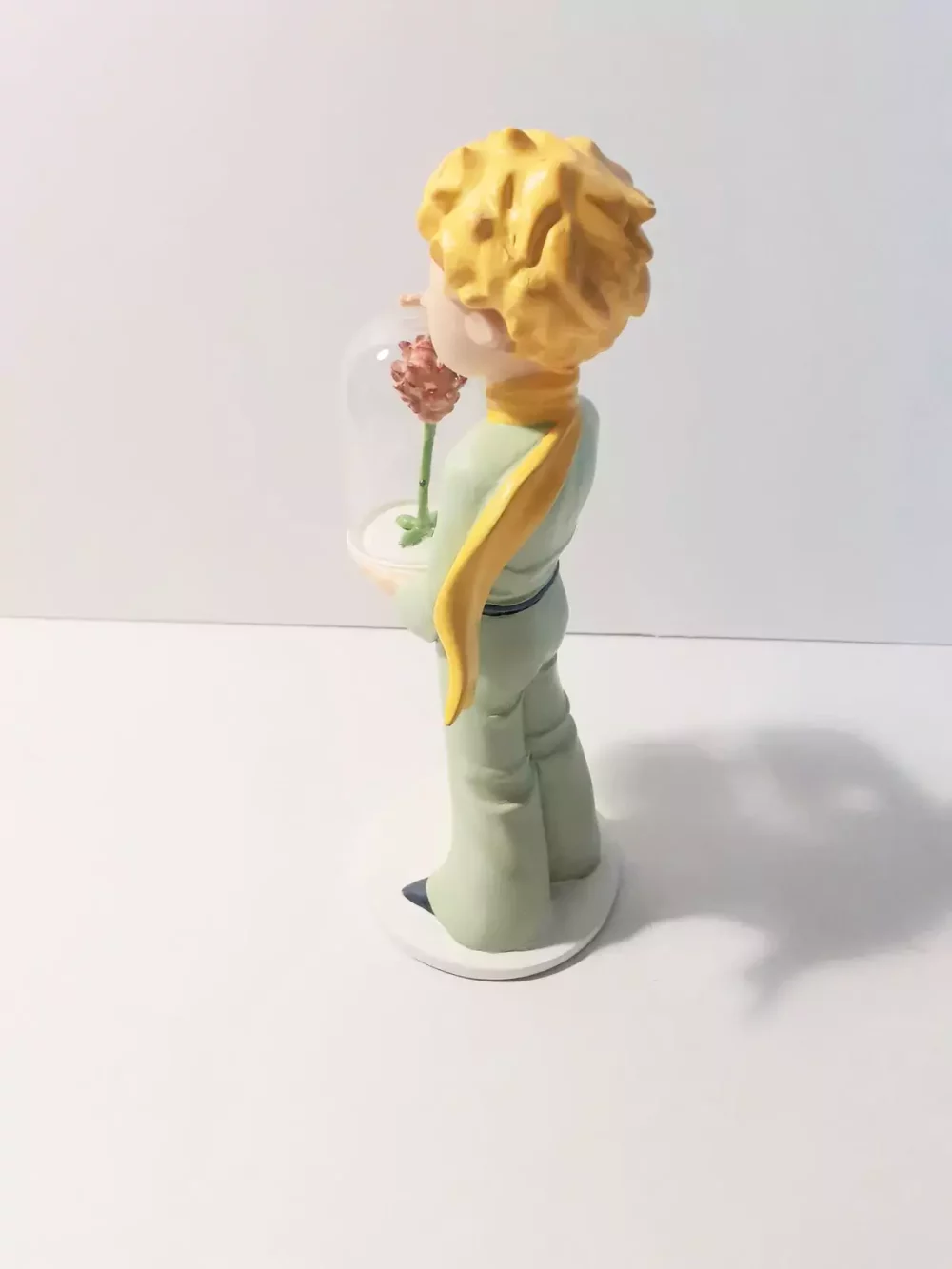 Figurine en résine et peinte à la main du petit prince et la rose. Personnages imaginés par St Exupéry qui nous plonge dans l'univers magique et poétique. 