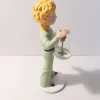 Figurine en résine et peinte à la main du petit prince et la rose. Personnages imaginés par St Exupéry qui nous plonge dans l'univers magique et poétique. 