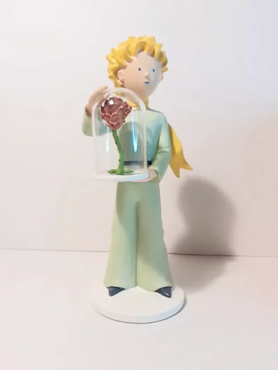 Figurine en résine et peinte à la main du petit prince et la rose. Personnages imaginés par St Exupéry qui nous plonge dans l'univers magique et poétique. 