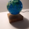 Ce globe représentant la Terre en lévitation au-dessus de son socle en bois émerveillera à coup sûr ses observateurs. Il diffuse par rétroéclairage interne une lumière radiale tamisée. Ce globe lumineux est une application parfaite de l'électromagnétisme : la sustentation dans les airs d'une part et la lumière générée à l'intérieur du globe par induction électrique d'autre part.