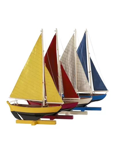 Maquette de bateau à voile en bois construite à la main, composée de quatre dériveurs, présente des couleurs primaires, lumineuses et ensoleillées.