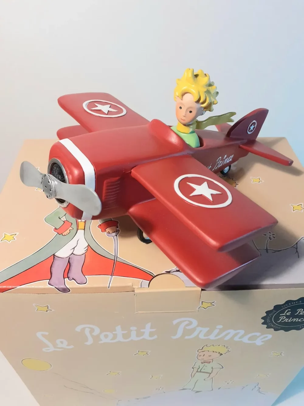 Figurine en résine et peinte à la main du petit prince en avion. Modèle de collection. Personnages imaginés par St Exupéry.