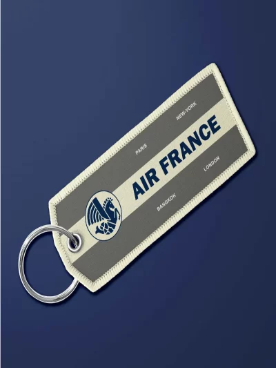 Porte-clé en tissu "flamme" Air France vintage gris. Très maniable, il se glisse partout et permet vite de retrouver ses clés.