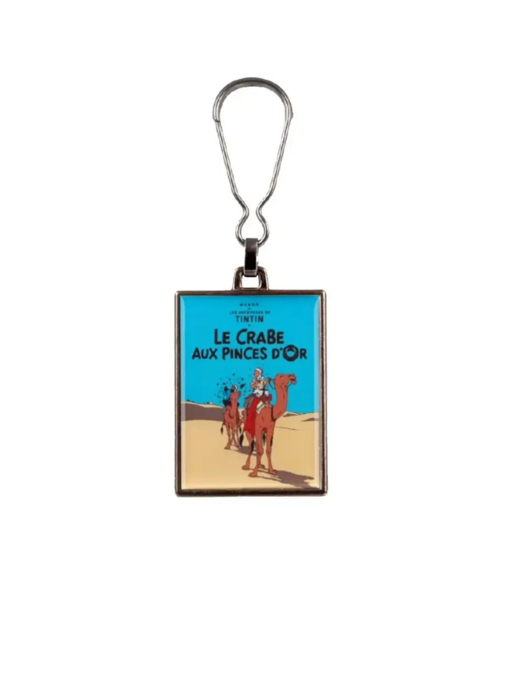 La couverture de l'album "Le crabe aux pinces d'or" en porte-clés métallique. Ce porte clés apportera une touche d’amusement et d’aventure à votre quotidien.